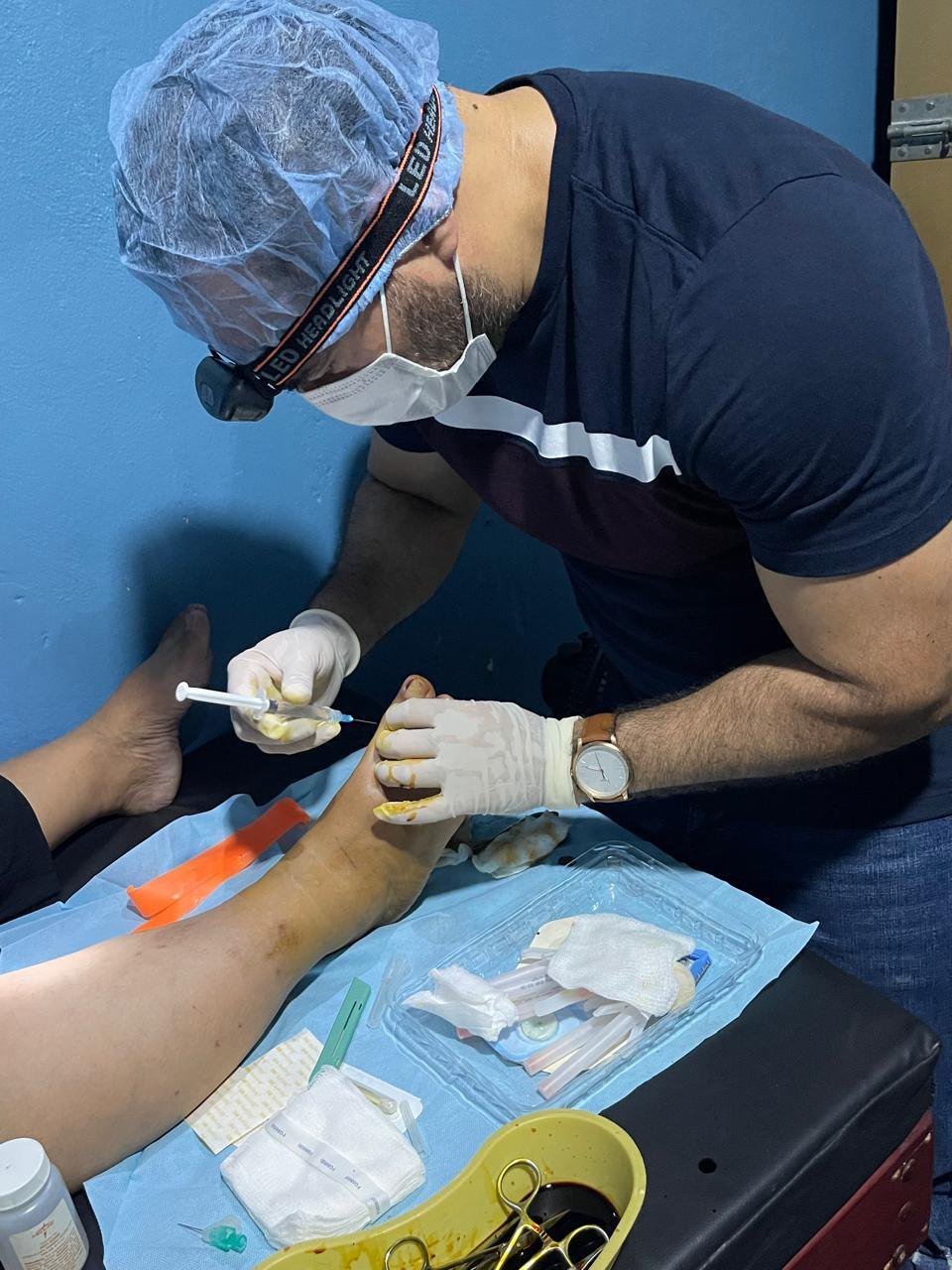 A clinician treating a patient’s foot in the low-cost clinic.