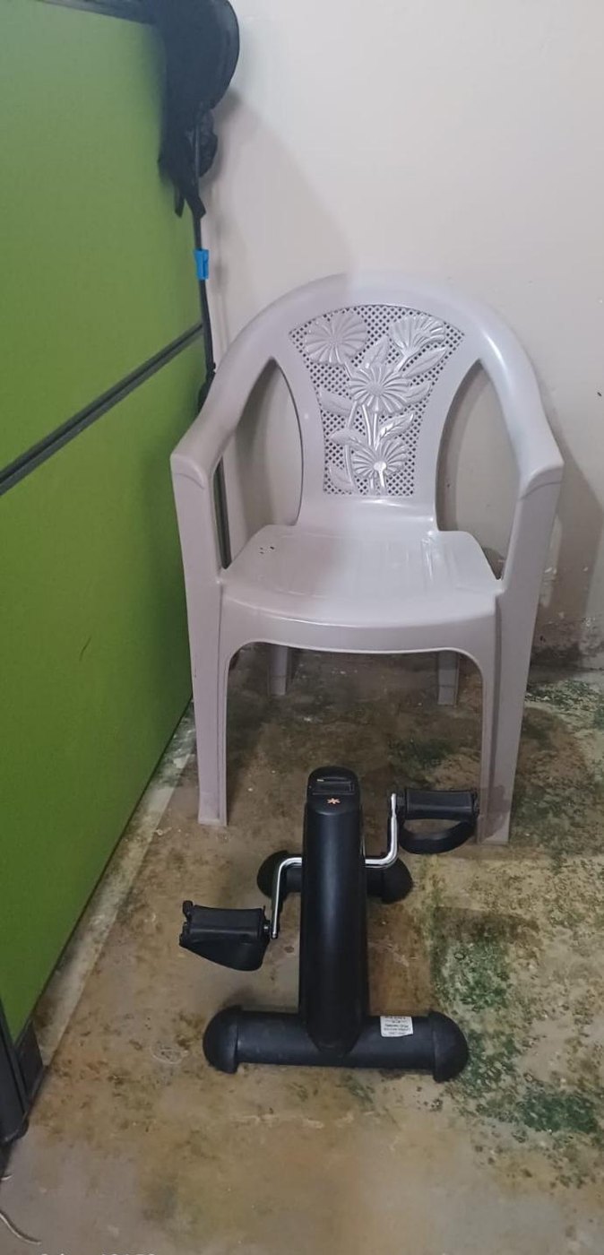 Pedal exerciser beside a chair in the Los Naranjos rehabilitation room.